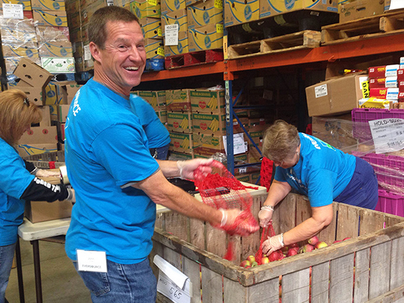 Volunteers from Eversource help sort and package apples in our warehouse for distribution to the community. 