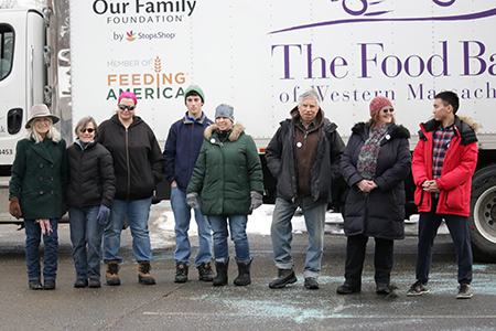 Eight staff-persons and volunteers from Amherst Survival Center are standing in front of one of The Food Bank's trucks. It is winter time.