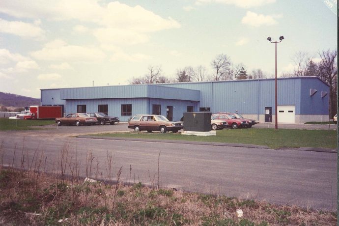 Image, color: The exterior of the Hatfield facility - a large rectangular blue building.