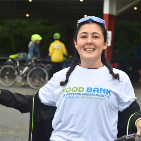 A Will Bike 4 Food participant wearing a bike shirt reading, "Food Bank of Western Massachusetts: Together, We End Hunger".