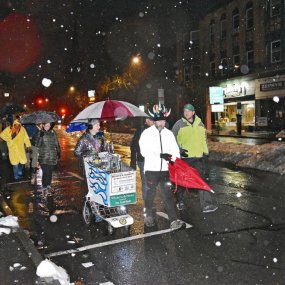 Monte and a group of marchers walk down Main Street in Northampton on a snowy morning before dawn.