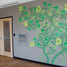 An acrylic installation in the lobby of the Food Bank, featuring the names of donors on the leaves of an abstracted squash plant.